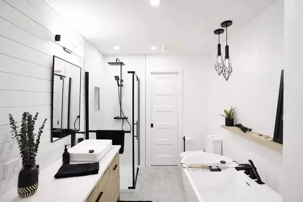 Salle de bains moderne avec une douche en verre noir, une baignoire contemporaine et un design épuré en noir et blanc.